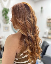 the back of a woman with long red hair in a salon